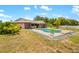 Scenic backyard pool with a lush green lawn and tropical palm trees, perfect for entertaining at 7615 17Th W Ave, Bradenton, FL 34209