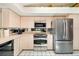 Compact kitchen design offering stainless steel appliances, light-colored cabinetry, and tiled floors for easy maintenance at 7615 17Th W Ave, Bradenton, FL 34209