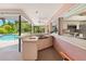 Outdoor kitchen featuring white countertop and sink with a pass through window overlooking the outdoor pool and patio at 7615 17Th W Ave, Bradenton, FL 34209