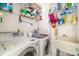 Functional laundry room equipped with a washer, dryer, shelving and a sink at 7615 17Th W Ave, Bradenton, FL 34209