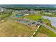 Aerial view of community amenities, featuring tennis courts, a parking lot, and a lakefront recreation area with a building at 8264 Summer Night Rd, Sarasota, FL 34241