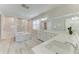 Spacious bathroom with a soaking tub, a walk-in shower, dual sinks, and white cabinetry at 8264 Summer Night Rd, Sarasota, FL 34241