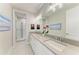 A modern bathroom features a double vanity with stone countertops and a glass enclosed shower at 8264 Summer Night Rd, Sarasota, FL 34241