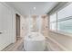 Large bathroom featuring an eye-catching tub flanked by glass shower enclosures and a large window at 8264 Summer Night Rd, Sarasota, FL 34241