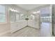 Bathroom with dual vanity sinks, white cabinetry, and a large mirror reflecting the view outside at 8264 Summer Night Rd, Sarasota, FL 34241