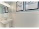 Charming powder room with pedestal sink, wainscoting, and stylish wall art with coordinating lighting at 8264 Summer Night Rd, Sarasota, FL 34241