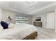 Bedroom features tray ceilings, ceiling fan, a large window overlooking the pool area, and an elegant dresser at 8264 Summer Night Rd, Sarasota, FL 34241