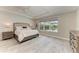 Bright bedroom featuring tray ceilings, a ceiling fan, and a large window with a view to the outdoor space at 8264 Summer Night Rd, Sarasota, FL 34241