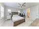 A well-lit bedroom features a wooden bed frame with nautical-themed bedding, a ceiling fan, and an en-suite bathroom at 8264 Summer Night Rd, Sarasota, FL 34241