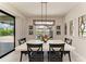 Bright dining room with white table and chairs, decorative mirrors, and view of the screened-in pool area at 8264 Summer Night Rd, Sarasota, FL 34241