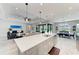 Open concept kitchen, living and dining area, with oversized island and stainless appliances and views of the pool at 8264 Summer Night Rd, Sarasota, FL 34241