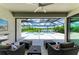 Cozy covered patio with comfortable seating overlooking the pool and tranquil lake views at 8264 Summer Night Rd, Sarasota, FL 34241