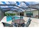Inviting screened pool area featuring a patio set for outdoor dining and serene lake views at 8264 Summer Night Rd, Sarasota, FL 34241