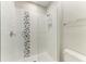 The glass enclosed shower features white tiling with decorative mosaic stripe, and a chrome shower head at 8264 Summer Night Rd, Sarasota, FL 34241