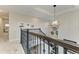 A staircase with iron railings is accentuated by a modern chandelier and white wood paneled wall with nautical-themed artwork at 8264 Summer Night Rd, Sarasota, FL 34241