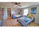 Spacious bedroom featuring two beds, bright natural light, ceiling fan, and playful decor, ideal for Gathering or guests at 8725 Aero Ave, North Port, FL 34287