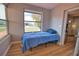 Cozy bedroom with wood-look flooring, a twin bed, and a window overlooking the outdoor area, enhancing natural light at 8725 Aero Ave, North Port, FL 34287