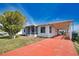 Charming single-story home featuring a covered carport, a screened-in porch, and a red brick-paved driveway at 8725 Aero Ave, North Port, FL 34287