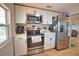 Well-equipped kitchen with stainless steel appliances, white cabinetry, light countertops, and modern fixtures at 8725 Aero Ave, North Port, FL 34287