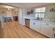 Bright kitchen with stainless steel dishwasher, white cabinetry, and view into dining area, enhancing open-concept design at 8725 Aero Ave, North Port, FL 34287