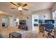 Bright open-concept living room featuring a ceiling fan and views of the connected kitchen and office space at 8725 Aero Ave, North Port, FL 34287