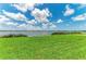 Lush green lawn and the serene lake create a tranquil backyard oasis at 909 Crosswind Ave, Sarasota, FL 34240