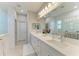 Bright bathroom featuring double vanity, quartz countertops, and a separate glass enclosed shower at 909 Crosswind Ave, Sarasota, FL 34240