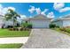 Charming single-story home boasting a well-manicured lawn, brick driveway, and attached two-car garage at 909 Crosswind Ave, Sarasota, FL 34240