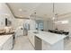 Open kitchen featuring an oversized island with seating, stainless appliances, and designer lighting at 909 Crosswind Ave, Sarasota, FL 34240