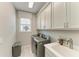 Convenient laundry room with ample counter space, cabinetry, sink, and modern appliances at 909 Crosswind Ave, Sarasota, FL 34240