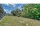 Grassy backyard with tree line on a sunny day at 946 N Beneva Rd # V26, Sarasota, FL 34232
