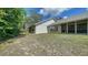 A view of the back of the house from the large grass backyard and tree line at 946 N Beneva Rd # V26, Sarasota, FL 34232