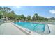 Outdoor pool with lounge chairs surrounded by greenery and a chain link fence at 946 N Beneva Rd # V26, Sarasota, FL 34232
