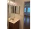 Modest bathroom with vanity and large mirror, adjoining bedroom and main living space at 10800 N Us Highway 19 # 237, Pinellas Park, FL 33782