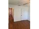 Clean bedroom featuring wood floors, white walls, closet, and an open doorway to the rest of the home at 10800 N Us Highway 19 # 237, Pinellas Park, FL 33782