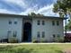 Two-story condo building with an open stairwell between units, set on a lush green lawn under a bright sky at 10800 N Us Highway 19 # 237, Pinellas Park, FL 33782