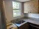 Kitchen with a stainless steel sink, light countertops, ample light from window, and wood-grain cabinetry at 10800 N Us Highway 19 # 237, Pinellas Park, FL 33782