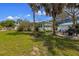 Spacious backyard with lush grass, palm trees, and outdoor amenities, perfect for relaxation and entertainment at 109 Maple Ave, Anna Maria, FL 34216
