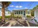 Charming backyard patio with seating, lush greenery, and access to the sunroom at 109 Maple Ave, Anna Maria, FL 34216