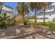 Relaxing backyard brick patio with outdoor furniture, grill, and mature tropical landscaping providing shade at 109 Maple Ave, Anna Maria, FL 34216