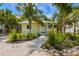 Inviting single-story home surrounded by swaying palm trees and lush landscaping, creating a tropical paradise at 109 Maple Ave, Anna Maria, FL 34216