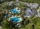 Overhead view of pools, tennis and recreation area with lush landscape at 12682 Shimmering Oak Cir, Venice, FL 34293