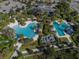 Aerial view featuring the resort-style pools and recreation area with lush tropical landscaping at 12682 Shimmering Oak Cir, Venice, FL 34293
