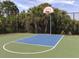 Community basketball court featuring a blue playing surface surrounded by a chain link fence at 12682 Shimmering Oak Cir, Venice, FL 34293