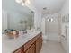 Bathroom with a single sink vanity, mirror, and a combined bathtub and shower with tiled surround at 12682 Shimmering Oak Cir, Venice, FL 34293