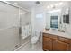 Bathroom with a glass-enclosed shower, tile surround, and single sink vanity at 12682 Shimmering Oak Cir, Venice, FL 34293