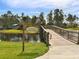 Wooden bridge leading to Lookout Point Island, surrounded by lush greenery and a serene lake at 12682 Shimmering Oak Cir, Venice, FL 34293