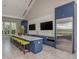 Modern community kitchen with a long island, barstool seating, dual wall-mounted TVs, and stainless appliances at 12682 Shimmering Oak Cir, Venice, FL 34293