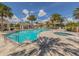 Gorgeous community pool and hot tub area surrounded by palm trees and comfortable lounge chairs at 12682 Shimmering Oak Cir, Venice, FL 34293