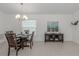 Bright dining room features a modern chandelier and a decorative cabinet with beach-themed artwork at 12682 Shimmering Oak Cir, Venice, FL 34293